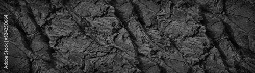 Black white rock texture background. Rough mountain surface with cracks. Close-up. Dark gray stone basalt background for design. Banner. Wide. Long. Panoramic. Website header.