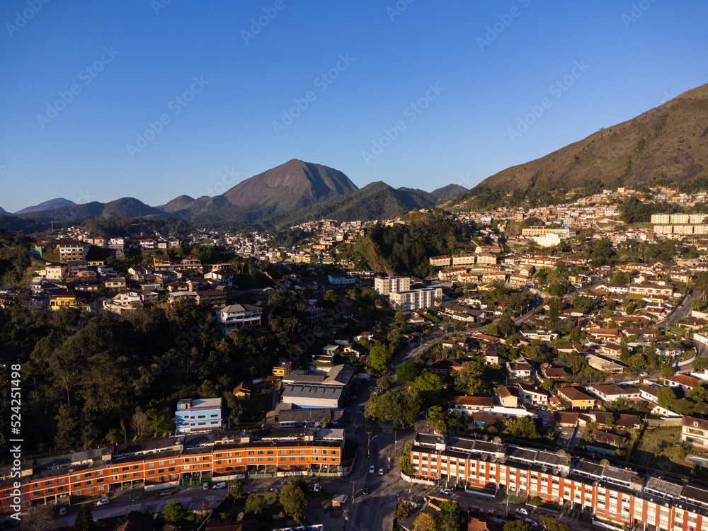 Aerial view of the city of Teresópolis. Mountains and hills with blue sky and many houses in the mountain region of Rio de Janeiro, Brazil. Drone photo. Araras, Teresópolis. Sunny day. Sunset