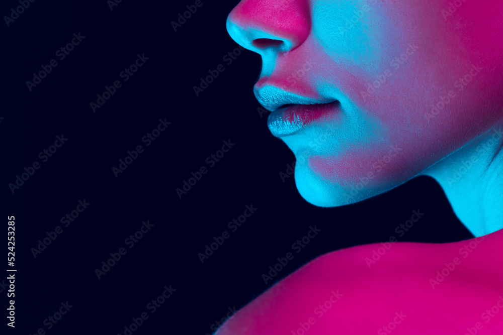 Closeup female lips, cheeks and nose isolated over dark background in neon light. Concept of cosmetology, skincare, cosmetics, plastic surgery, ad Closeup female lips, cheeks and nose isolated over dark background in neon light. Concept of cosmetology, skincare, cosmetics, plastic surgery, ad