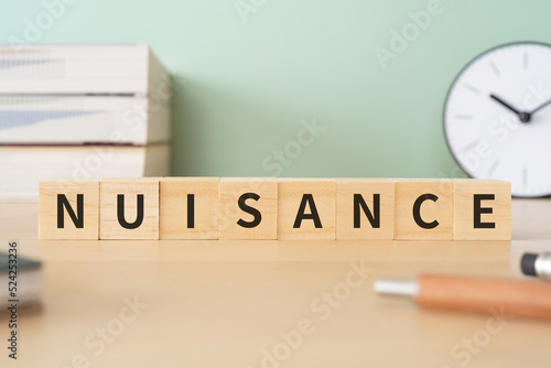 Bild auf Leinwand 迷惑行為のイメージ｜「NUISANCE」と書かれたブロックが置かれたデスク