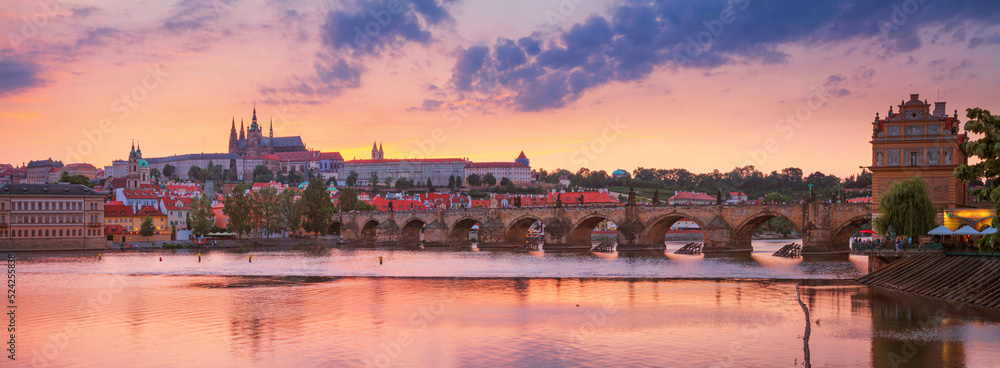 Naklejka premium City summer landscape at sunset, panorama, banner - view of the Charles Bridge and castle complex Prague Castle in the historical center of Prague, Czech Republic