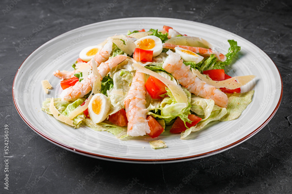fresh salad with shrimp and parmesan on a black background fresh salad with shrimp and parmesan on a black background