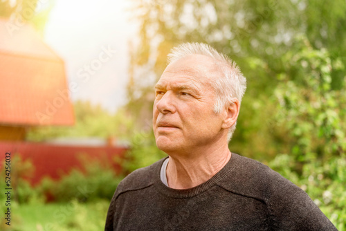 Portrait of an elderly man against the background of the countryside