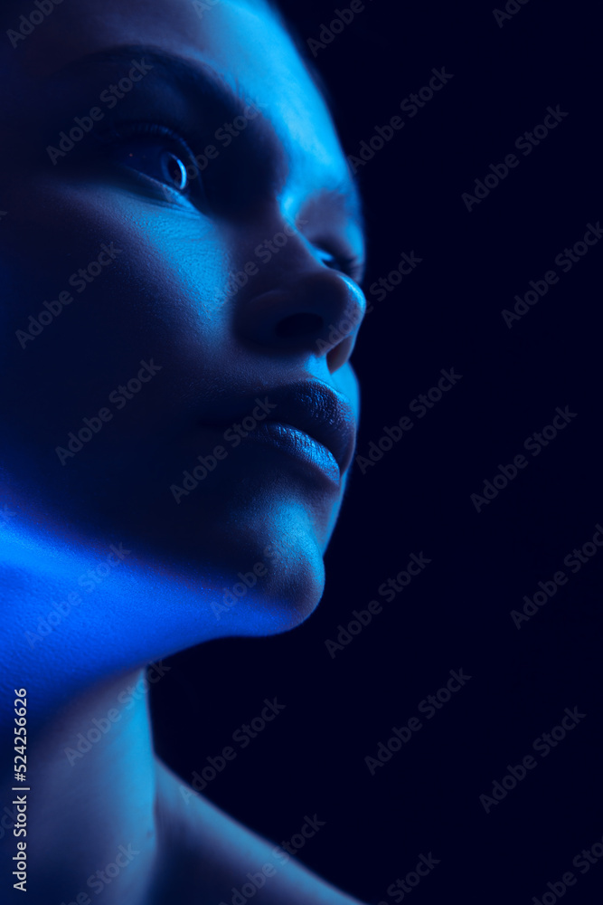 Marvelous night. Closeup portrait of young woman in neon light on dark background. Monochrome. Cyberpunk style, beauty, cosmetics concept. Marvelous night. Closeup portrait of young woman in neon light on dark background. Monochrome. Cyberpunk style, beauty, cosmetics concept.