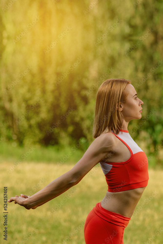 Young attractive blonde healthy woman doing fitness stretching outdoors