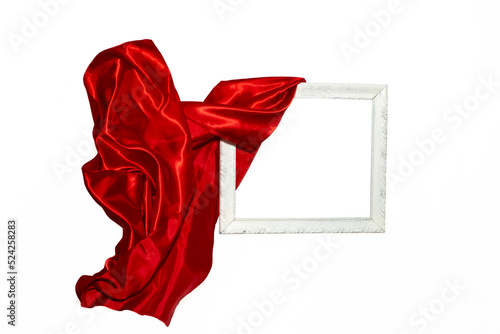 Flying red satin cloth unveiling a white vintage frame. photo