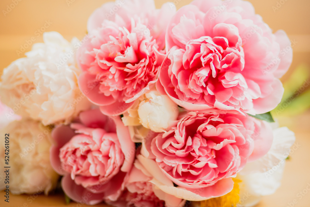 Bouquet of pink and white peonies lying on the table