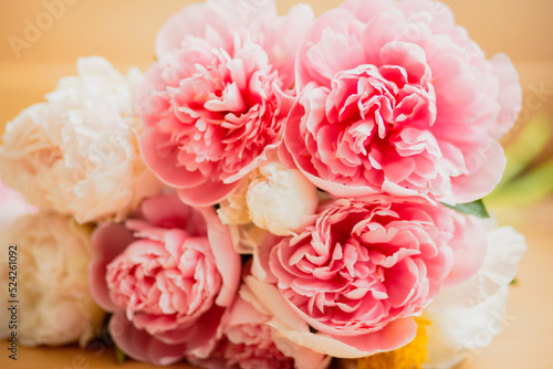 Bouquet of pink and white peonies lying on the table