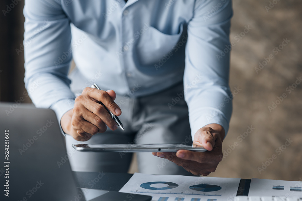 Business men are looking at the company's financial documents on tablets to analyze problems and find solutions before bringing the information to a meeting with a partner. Financial concept. Business men are looking at the company's financial documents on tablets to analyze problems and find solutions before bringing the information to a meeting with a partner. Financial concept.