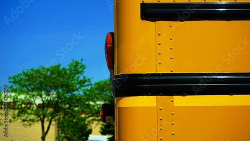 Closeup of tail lights of a yellow school bus parked outdoors