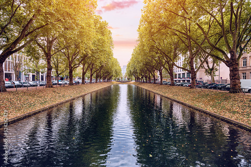 Konigsallee - a popular tourist and historical attraction of the city of Dusseldorf in Germany. A canal planted with plane trees with fashionable shopping galleries photo