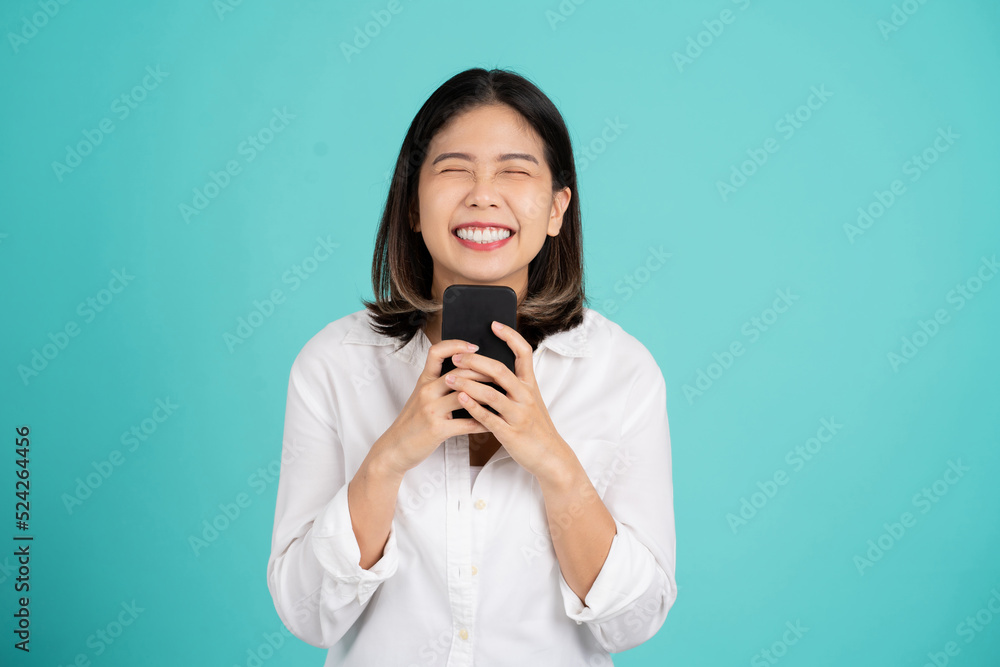 Smiling cheerful young asian woman wearing a white shirt standing isolated on bright green background. She looking camera, studio portrait Smiling cheerful young asian woman wearing a white shirt standing isolated on bright green background. She looking camera, studio portrait