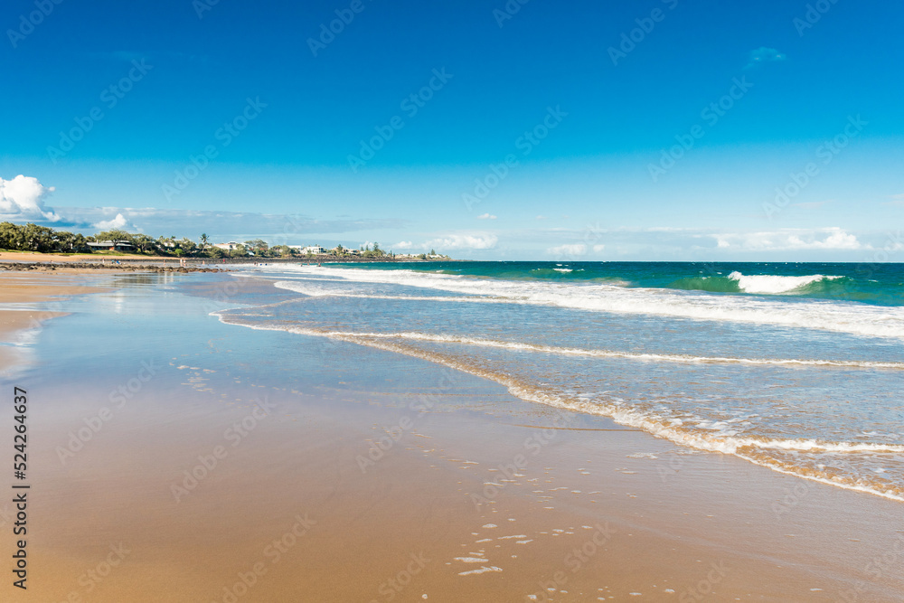 Beautiful ocean sandy beach nature background with town on the horizon. Low tide.