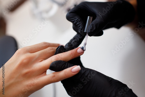 Manicure process female hands finger nails varnish polish.
