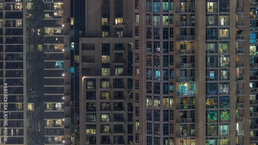 Big glowing windows in modern residential buildings timelapse at night, in rows of windows light shines. Big glowing windows in modern residential buildings timelapse at night, in rows of windows light shines.