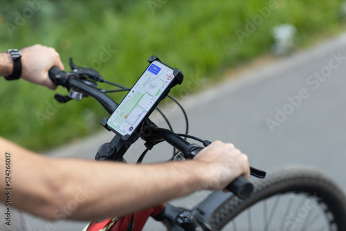 Man planning route using GPS navigation application in mobile phone on his bicycle bike © primipil