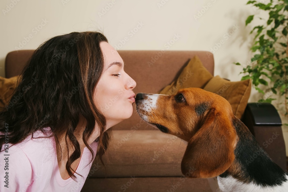 A woman and a dog kiss