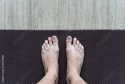 Obraz na płótnie Two legs on anti-slip plastic mat to prevent slip and fall. Rubber flooring for pools and wet rooms. w salonie