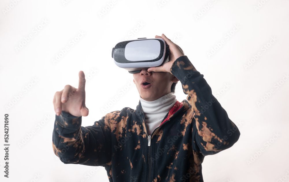 Young man using virtual reality headset looking up and interacting with Facebook Youtube Steam VR content. Isolated on a white background studio portrait. VR, future, gadgets, technology, concept
