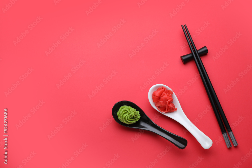 Swirl of wasabi paste, pickled ginger and chopsticks on red background, flat lay. Space for text Swirl of wasabi paste, pickled ginger and chopsticks on red background, flat lay. Space for text