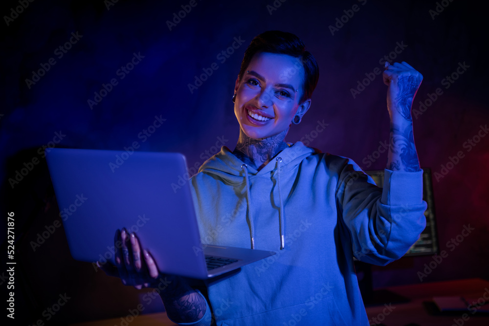 Photo of attractive lucky it specialist dressed sweatshirt piercing rising fist holding modern gadget indoors workplace workstation Photo of attractive lucky it specialist dressed sweatshirt piercing rising fist holding modern gadget indoors workplace workstation