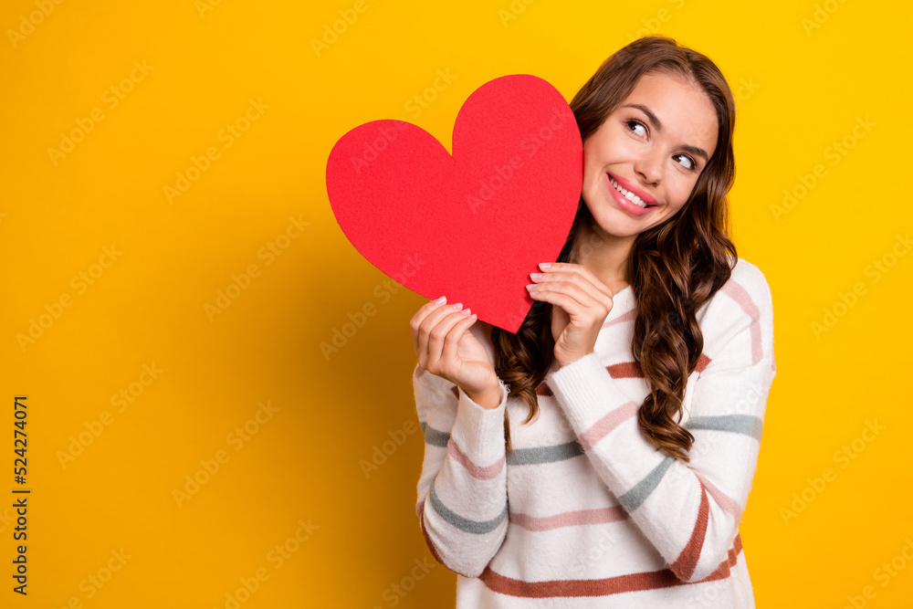 Photo of cheerful nice person hands hold heart symbol postcard look empty space isolated on yellow color background Photo of cheerful nice person hands hold heart symbol postcard look empty space isolated on yellow color background