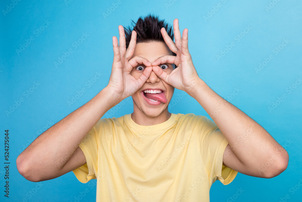 Funny guy holds hands near eyes pretends looking through binoculars shows zero okay gesture Funny guy holds hands near eyes pretends looking through binoculars shows zero okay gesture