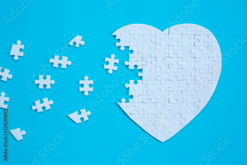 White heart shape of jigsaw puzzle pieces on blue background. concepts of problem solving, business success, teamwork, Team playing jigsaw game incomplete, Texture banner with copy space for text