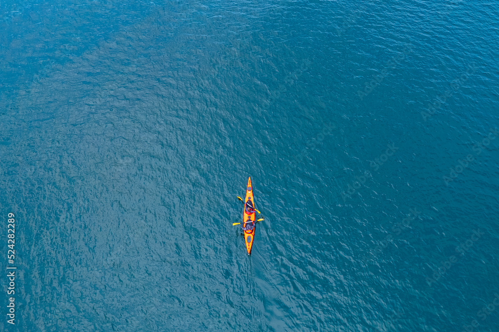 Red kayak boat two rowers on blue turquoise water sea, sunny day. Concept banner travel, aerial top view - obrazy, fototapety, plakaty 