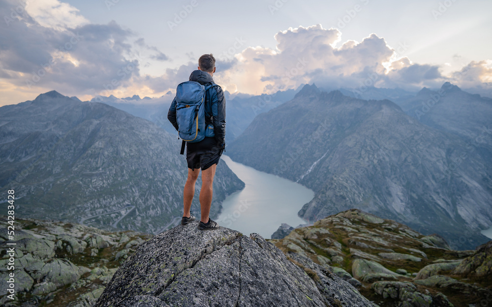 Man on top at sunset surrounded by mountains. Success Business Leadership, Winner Man on top. Business Sport and active life concept Man on top at sunset surrounded by mountains. Success Business Leadership, Winner Man on top. Business Sport and active life concept