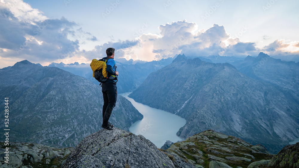 Man on top at sunset surrounded by mountains. Success Business Leadership, Winner Man on top. Business Sport and active life concept