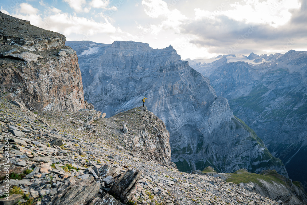 Fototapeta premium Man on top of mountain. Epic shot of adventure hiking in mountains alone outdoor active. Travel, adventure or expedition concept. Sports, adventure, happiness, freedom