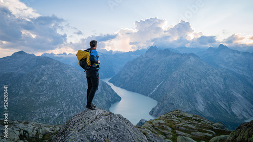 Man on top at sunset surrounded by mountains. Success Business Leadership, Winner Man on top. Business Sport and active life concept