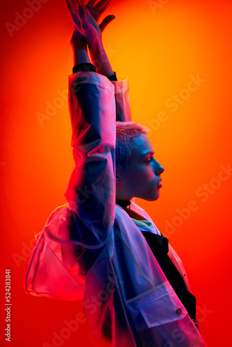 Foto Futuristic woman raising arms under neon light