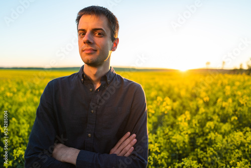 Man in the field . Agriculture - country outdoor scenery, warm sunset light.