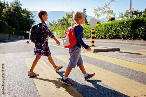 Fotobehang Pedestrian schoolchildren with backpacks crossing the road at a crosswalk on the way to school, back to school, school time, child safety, traffic road rules