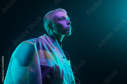 Futuristic young female looking at neon light photo