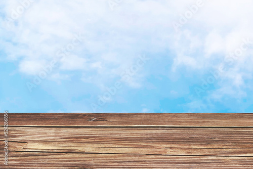 Wooden board empty table in front of blurred background. Perspective light brown wood over blurred blue sky, can be used for display or montage your products. Mock up for display of product.