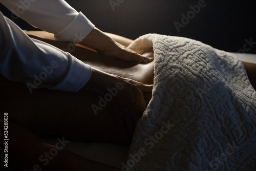 Terapeuta aplicando massagem nas costas de um paciente.