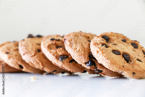 фотографія Delicious chocolate chip cookies lined up on white table, a tasty biscuit snack,