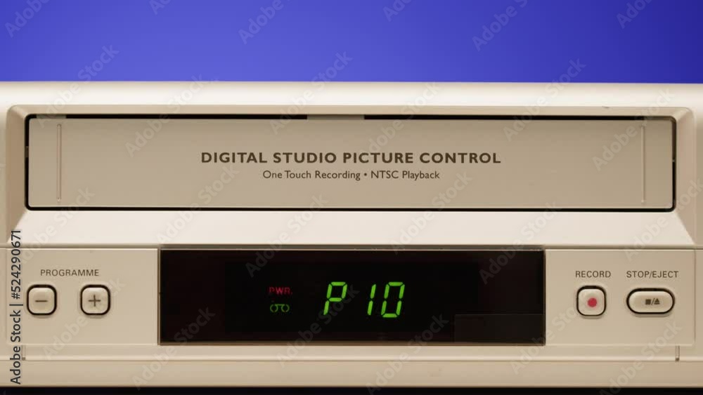 Old video recorder close-up, VHS. Retro player, vintage video cassette broadcasting on blue background, audio tape. Old video recorder close-up, VHS. Retro player, vintage video cassette broadcasting on blue background, audio tape.