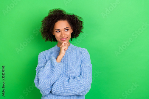 Photo of clever thinking businesswoman with wavy coiffure dressed blue pullover look empty space isolated on green color background