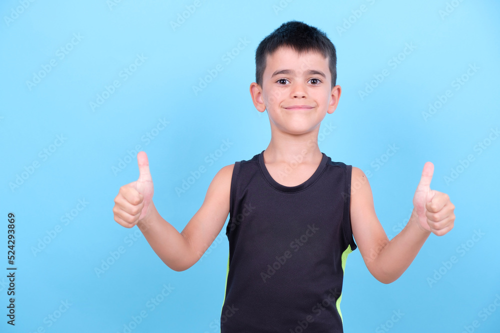 happy child with thumbs up on blue background. Optimistic and positive happy child with thumbs up on blue background. Optimistic and positive