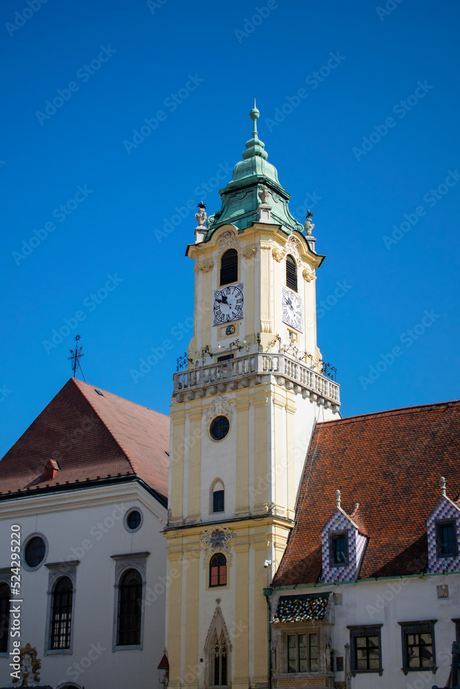 The old town hall's beautiful beige tower in Bratislava's main square, on a beautiful day. 
Bratislava, Slovakia