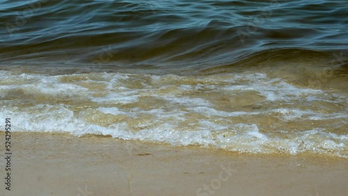 Песчаный пляж на Балтийском море в Гданьске, брызги волн у берега, крупный план, блестящие на солнце брызги волн