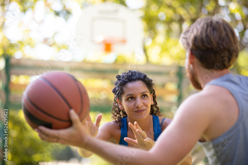 couple playing basketball on outdoor court