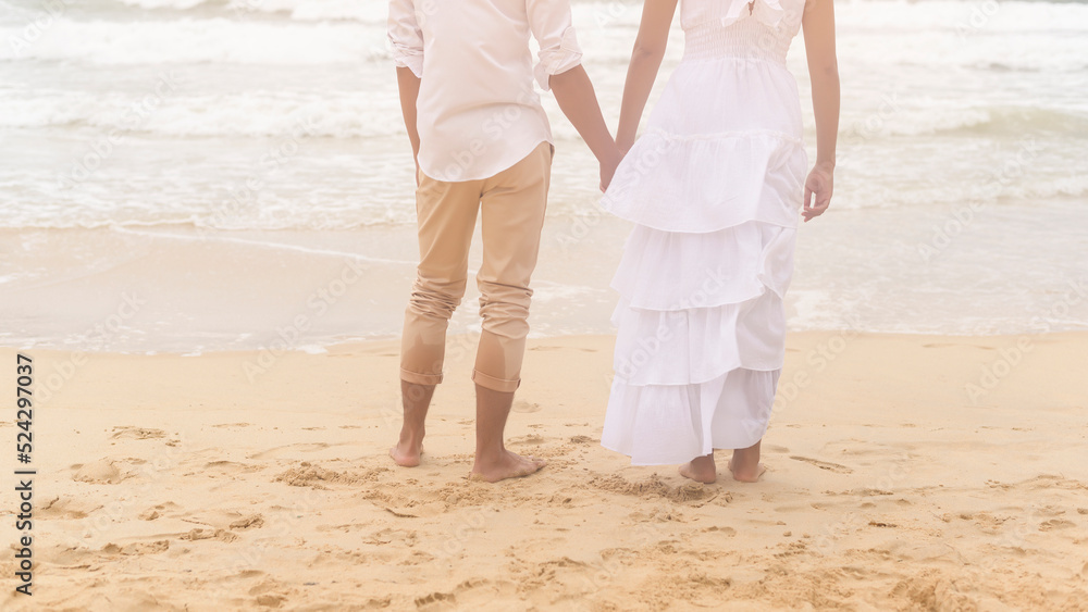 Happy young couple wearing white dress on the beach on holidays, travel, romantic, wedding concept Happy young couple wearing white dress on the beach on holidays, travel, romantic, wedding concept