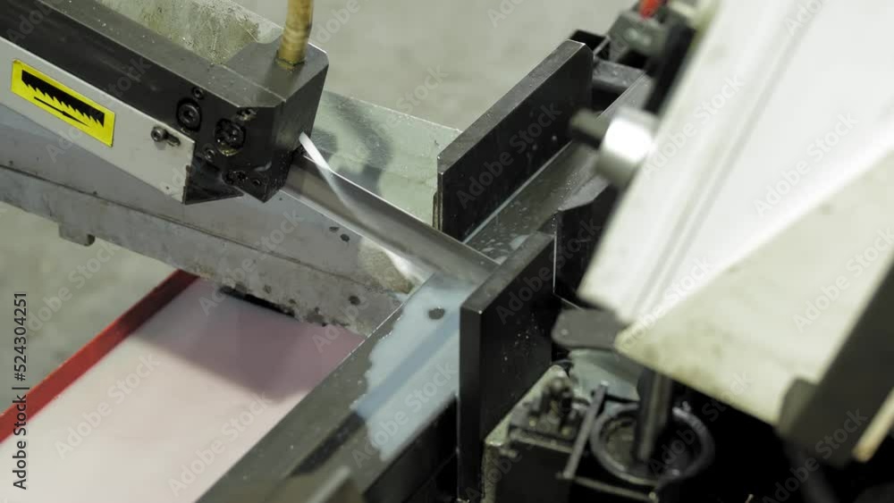 The automatic band saw machine cutting the square tubes with water base coolant method. The machine tool for industrial purpose. The automatic band saw machine cutting the square tubes with water base coolant method. The machine tool for industrial purpose.