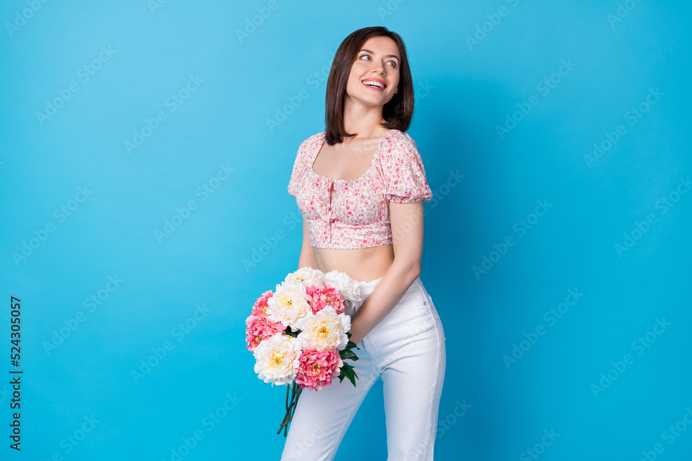 Photo portrait of winsome young lady hold bouquet date present boyfriend wear stylish flower print look isolated on blue color background Photo portrait of winsome young lady hold bouquet date present boyfriend wear stylish flower print look isolated on blue color background