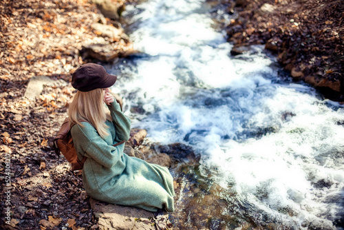 Portrait of a young happy woman tourist on a lake in the autumn forest. Forest Lake and Tourism